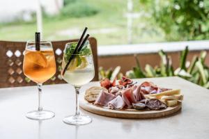 due bicchieri di vino e un piatto di cibo su un tavolo di Hotel Job a Monclassico