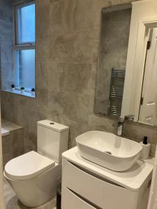a bathroom with a white toilet and a sink at Spectacular 2 Bed Apartment With Lovely Terrace - 1 The Southwell in London