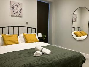 ein Schlafzimmer mit einem Bett mit gelben Kissen und einem Spiegel in der Unterkunft Spectacular 2 Bed Apartment With Lovely Terrace - 1 The Southwell in London
