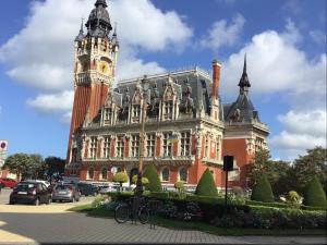 a large building with a clock tower on top of it at VINTAGE CARAVANE in Les Attaques