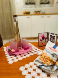 a table with a vase on a pink plate with cups at Cozy place in Kozani