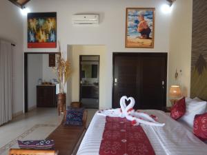 トランベンにあるVilla Omah Semarのベッドルーム1室(白いリボンのベッド1台付)