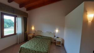 a bedroom with a green bed and a window at Sa Rocca Sport e Resort in Guspini