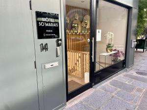 une porte donnant accès à un magasin avec un panneau. dans l'établissement Hôtel So Marais, à Paris