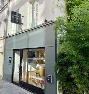 un front de magasin avec un panneau sur le côté d'un bâtiment dans l'établissement Hôtel So Marais, à Paris