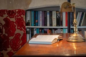 巴斯的住宿－Somerset House Apartment - Charming Period 1BD，一张桌子上的开放式书,带灯
