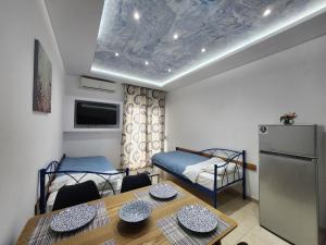 a small room with a dining table and a refrigerator at The Blue Beach Apartments in Nea Peramos