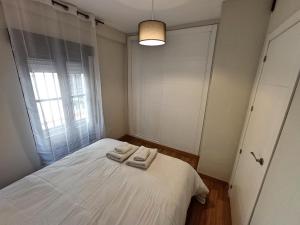 1 dormitorio con 1 cama con 2 toallas en Apartamento DON MANUEL, en Córdoba