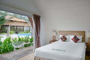 a bedroom with a bed and a view of a pool at Eden Beach Resort by EHM in Koh Rong Sanloem