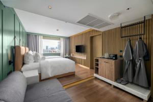 a hotel room with a bed and a television at Maison Hotel Bangkok in Bangkok