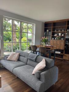 Sala de estar con sofá gris y mesa en Ferienwohnung im Obstgarten, en Bad Pyrmont