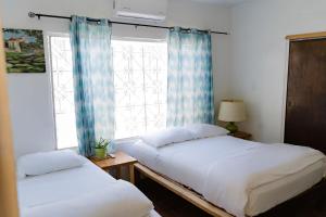Duas camas num quarto com uma janela em Desert Heart Hostel em San José del Cabo