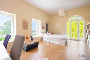 a bedroom with a bed and a teddy bear sitting on a chair at Villa QUEEN Marseille avec jardin, piscine et spa chauffé interieur - 13 couchages in Marseille