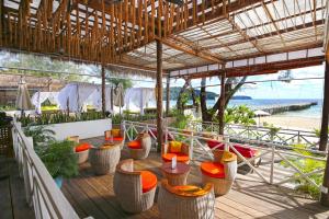 restauracja z krzesłami i stołami na tarasie z plażą w obiekcie Eden Beach Resort by EHM w mieście Koh Rong Sanloem