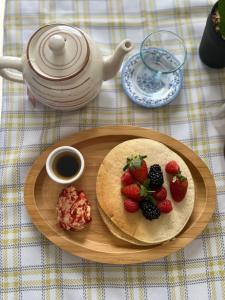 a plate of food with strawberries and blackberries on a table at مورايا Murraya in Abyār ‘Alī