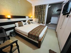 a hotel room with a bed and a window at Hotel Mani International in Patna