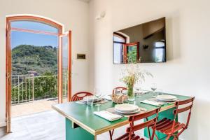 comedor con mesa, sillas y ventana en I Monolocali, en SantʼAgata sui Due Golfi