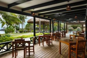 a restaurant with tables and chairs on a deck at Waya Island Resort in Yalombi