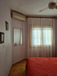 a bedroom with a red bed and a window at Chalet Adosado Unifamiiar Rocasol Beach Torrevieja in Torrevieja +28 photos