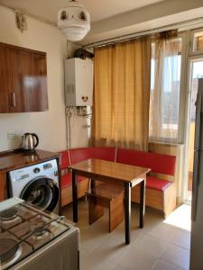una pequeña cocina con mesa y sofá rojo en Amiryan apartment, en Ereván