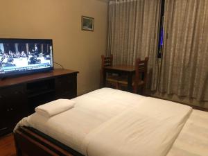 a hotel room with a bed and a television at CASA FRANCISCANA 1 in Quito