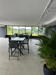 a group of tables and chairs in a room with windows at Apartment in Umhlanga in Umhlanga