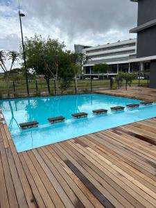 a large blue swimming pool with a wooden deck at Apartment in Umhlanga in Umhlanga