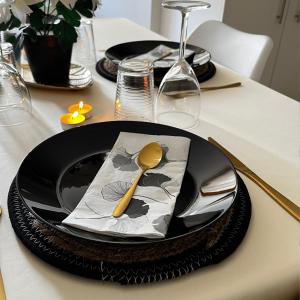 una mesa con un plato negro con una cuchara. en Beau petit appartement au coeur de l'ariege., en Tarascon-sur-Ariège