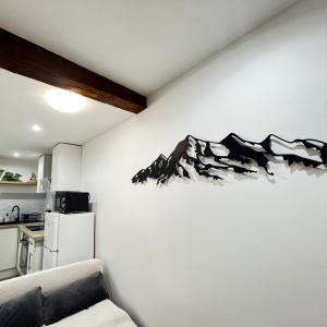 una cocina con una pared con una pintura de lobos en Beau petit appartement au coeur de l'ariege. en Tarascon-sur-Ariège