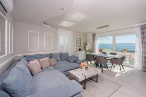 ein Wohnzimmer mit einem blauen Sofa und einem Tisch in der Unterkunft Filip in Crikvenica