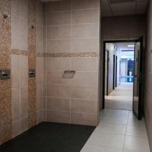 a bathroom with a walk in shower with a glass door at Hotel Belaria Resort in Opava