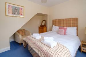 1 dormitorio con 1 cama con toallas en 2 Ogilvie Lodge, en Thorpeness