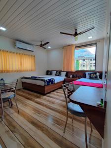 a bedroom with two beds and a table and chairs at Hotel Starlit in Navi Mumbai