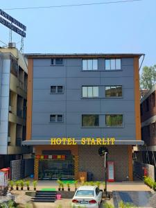 Un hotel Starlin con un coche aparcado delante de él en Hotel Starlit, en Navi Mumbai