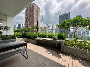 a balcony with a bench and a view of a city at Heaven Cottage KLCC Suite in Kuala Lumpur