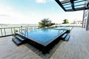 a swimming pool on a balcony with a view of the ocean at Lovina 27-AB at One Residence(near Ferry & Megamall) in Batam Center