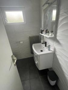 a white bathroom with a sink and a mirror at La grande bellezza in Martinšćica