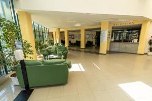 eine Lobby mit einer grünen Couch in einem Einkaufszentrum in der Unterkunft Hotel Slavyanski in Sonnenstrand