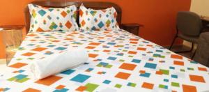 a bed with a colorful comforter on it at RÉSIDENCENGUARY in Dakar