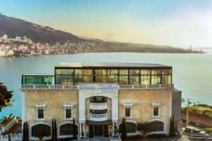 a building in front of a body of water at Monte Cassino in Jounieh