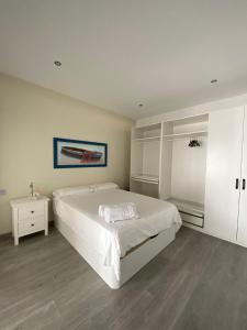 - une chambre blanche avec un grand lit et une table dans l'établissement Apartamento en playa de la Albufereta, à Alicante