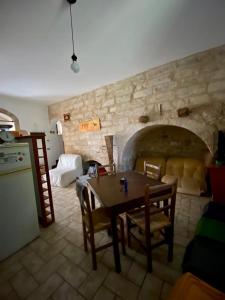 ein Wohnzimmer mit einem Tisch und einer Steinmauer in der Unterkunft Casa Arianna in Ragusa