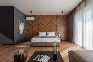 1 dormitorio con 1 cama y pared de madera en Didukh Eco Hotel&Spa en Bukovel