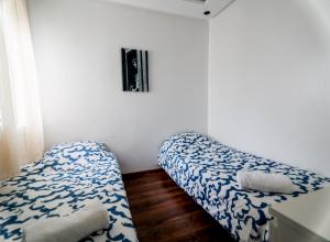 Zimmer mit 2 Betten in einem weißen Zimmer in der Unterkunft Cozy condo near to the beach in Dar Bouazza