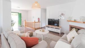 sala de estar con sofá blanco y TV en Villa Cañadu Nerja by Ruralidays, en Nerja