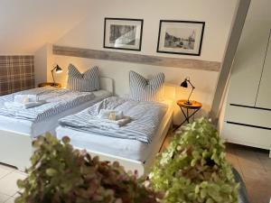 two beds in a room with two lamps and plants at Weberhof Apartment 2 in Münster