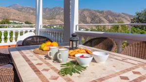 una mesa con un plato de comida en el balcón en Villa Cañadu Nerja by Ruralidays, en Nerja