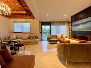 a large living room with couches and a tv at Golf view Villa with Jacuzzi- By AppartAli in Bouskoura