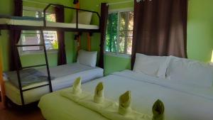 dwa łóżka piętrowe w pokoju z dwoma łóżkami piętrowymi rozmiar x rozmiar x wymiar w obiekcie Na Na Doo Homestay w mieście Chiang Rai