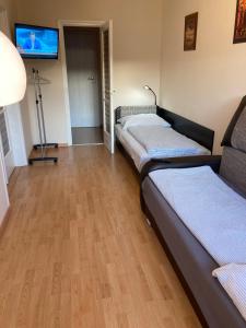 a room with three beds and a flat screen tv at Center One Apartman in Debrecen